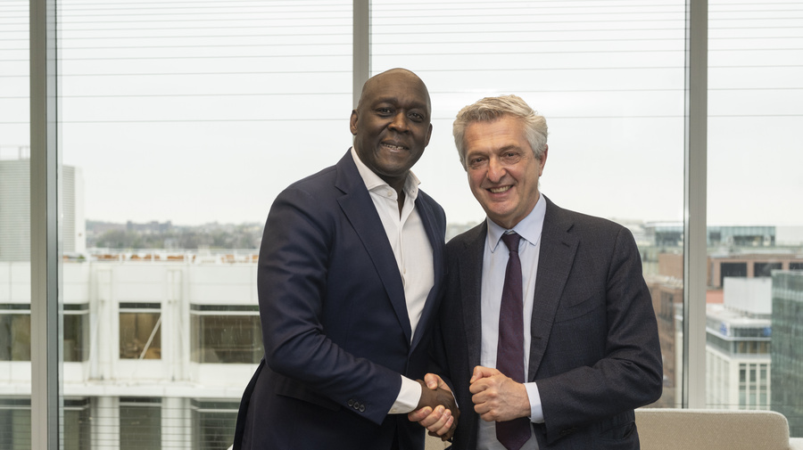 Two men shaking hands and posing for the camera