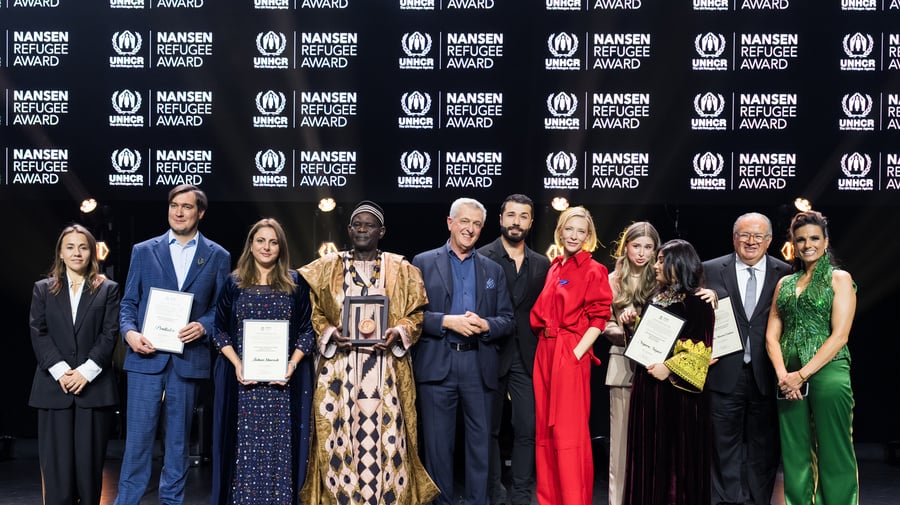 A group of people stand in a line on a stage