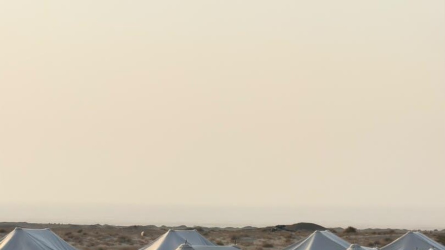 أم وأب يبتسمان وهما يحملان طفليهما.
