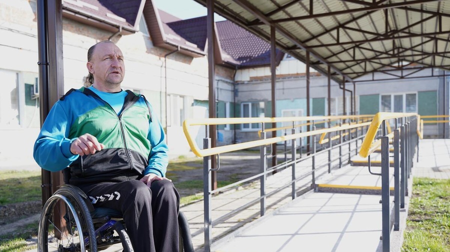 A man sitting in a wheelchair pictured outside his accommodation
