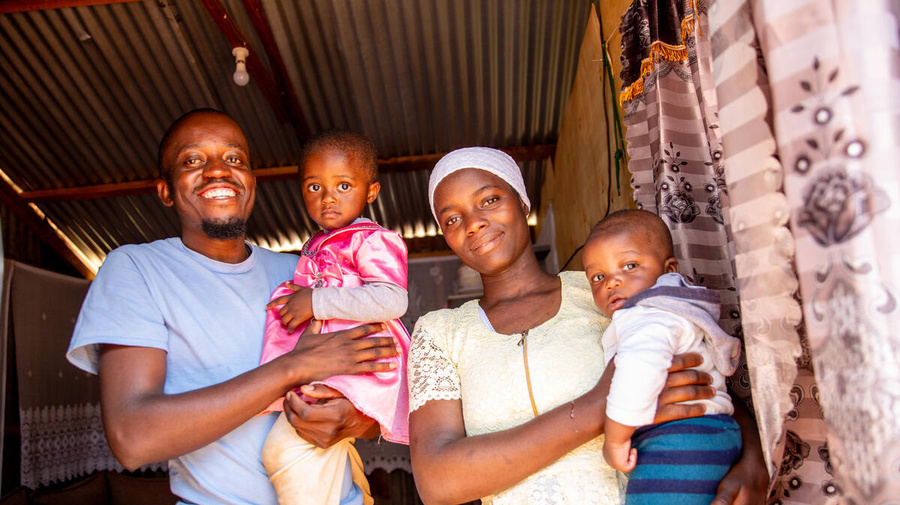 A smiling mother and father hold their two children.
