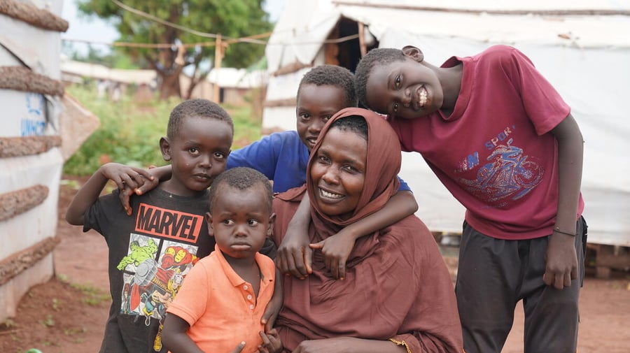 A Sudanese woman is pictured with her four young sons in a refugee settlement.