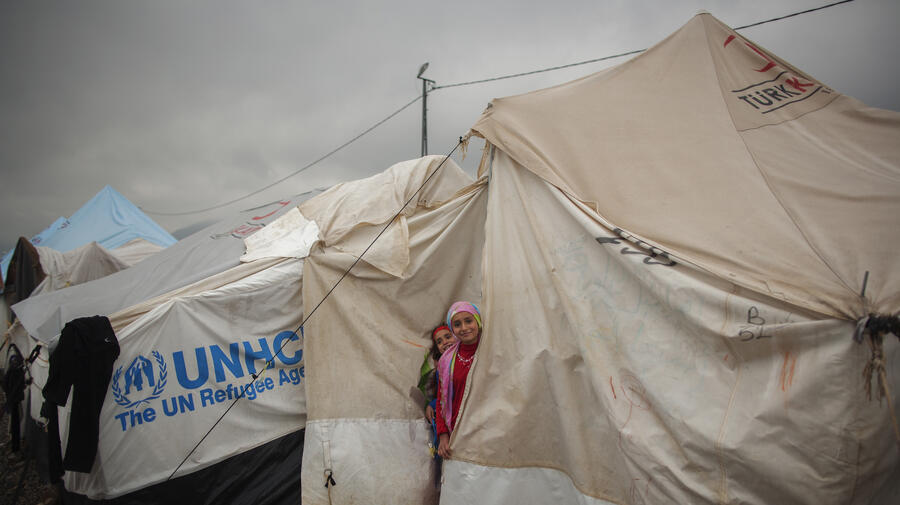 Young Syrian refugees look out from the door of their family's tent at a camp in Turkey. The number of refugees is expected to continue growing in the region.