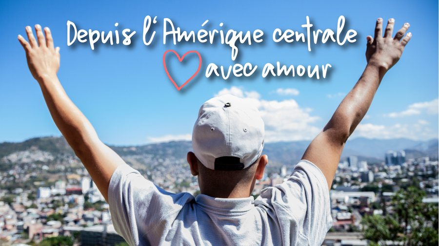 Une personne se tient debout, les bras en l'air, et regarde une ville.