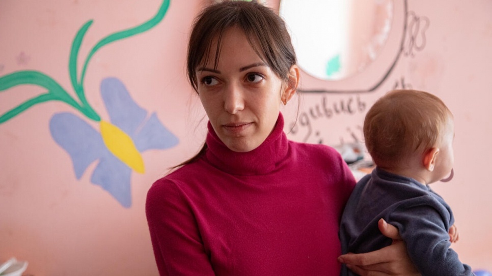 Oleksandra在穆卡切沃洲立大學宿舍的房間，抱着她七個月大的女兒Polina。© UNHCR/Igor Karpenko