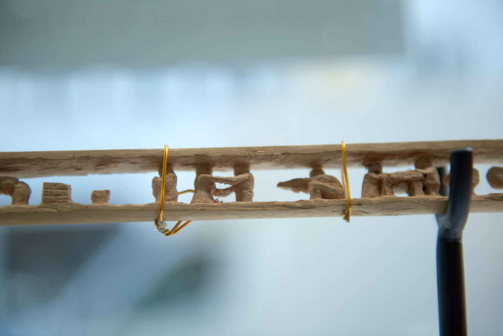 This broomstick, carved by Tarek Mohamed Hamden, tells the story of his life. Here he depicts the conflict in Syria