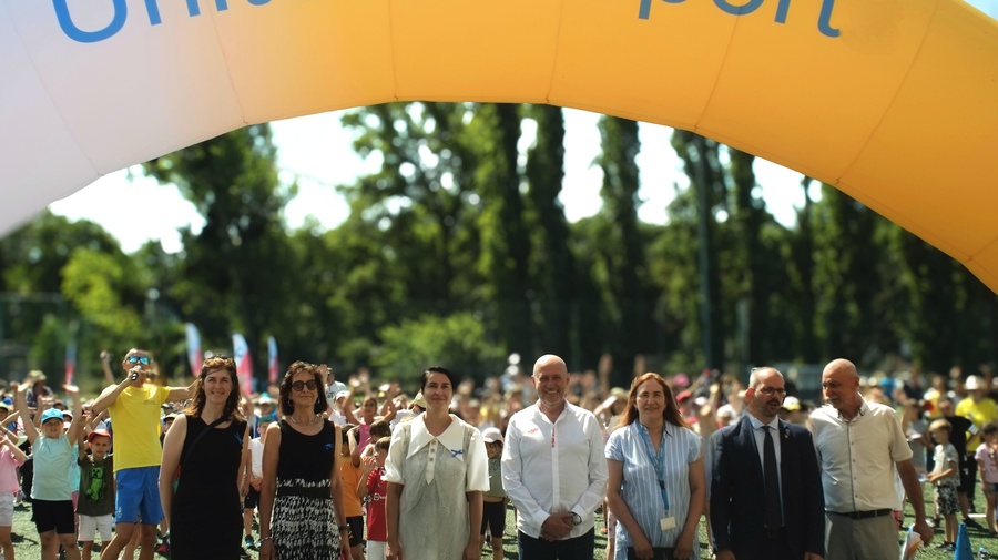A group of people standing under a large inflatable arch