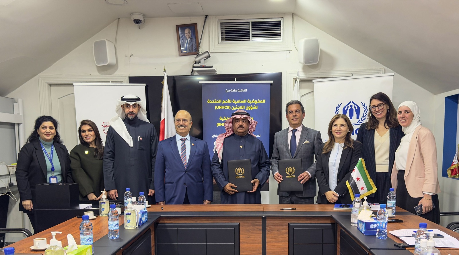 Representatives from UNHCR Syria and the Royal Humanitarian Foundation sit at a table signing a grant agreement.
