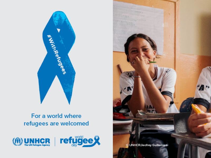 On the right, a picture of two young girls smiling and sitting at their desks in a classroom. On the left, a blue ribbon with the inscription "With Refugees". Text under the ribbon reads: "For a world where refugees are welcome".