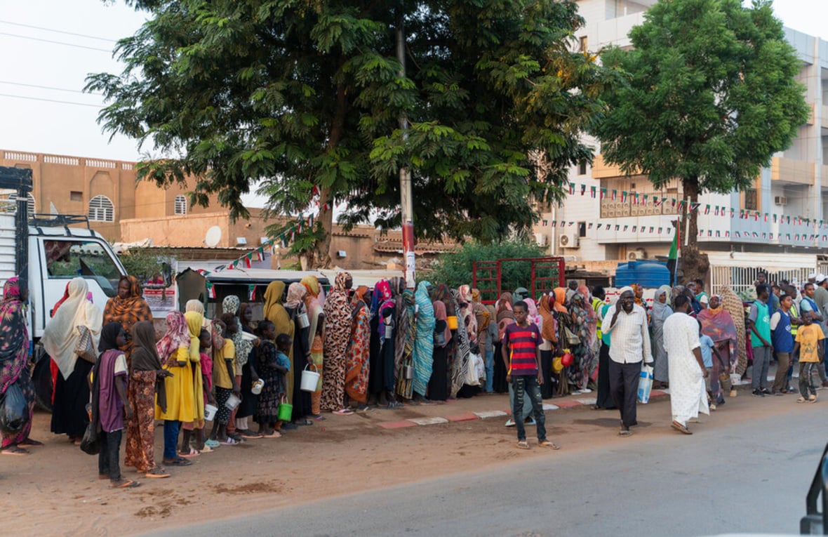 Recently displaced families from El Fasher queue for a food distribution alongside long-term residents in Omdurman, Sudan's second largest city.