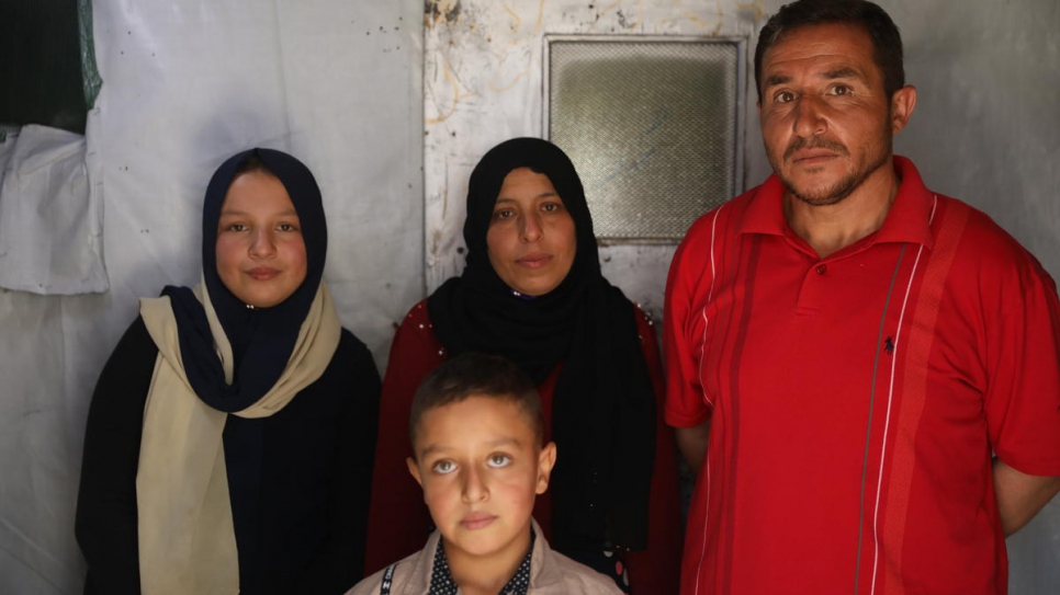 Khalil (right) with his family, including 12-year-old daughter Nahed (left) who dropped out of school to earn money picking vegetables. © UNHCR/Houssam Hariri