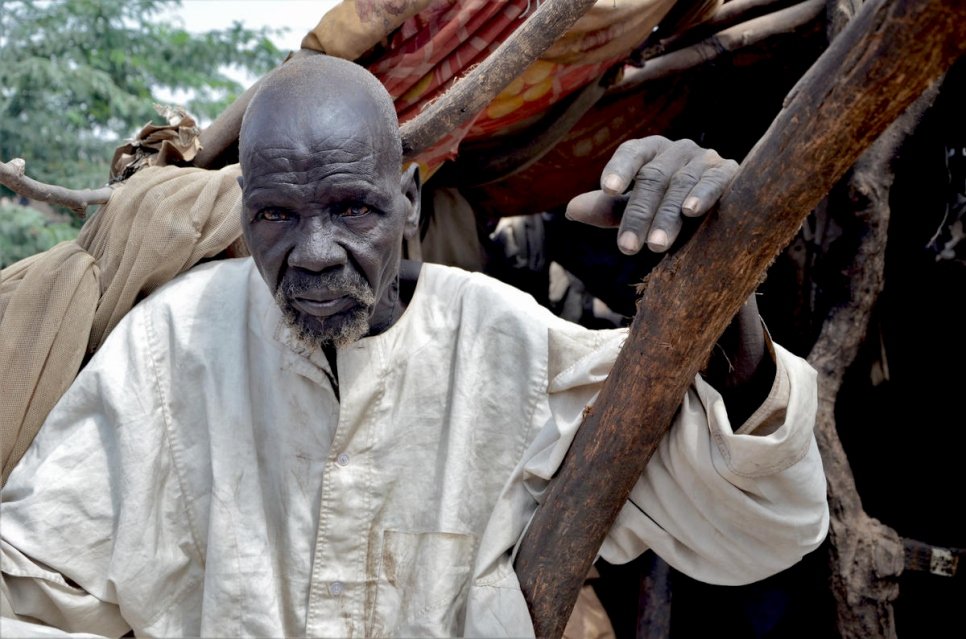 South Sudanese refugee, Bak, 80, sits in his shelter that was damaged by massive flooding in Sharq Al-Nile, Sudan. © UNHCR/Roland Schönbauer
