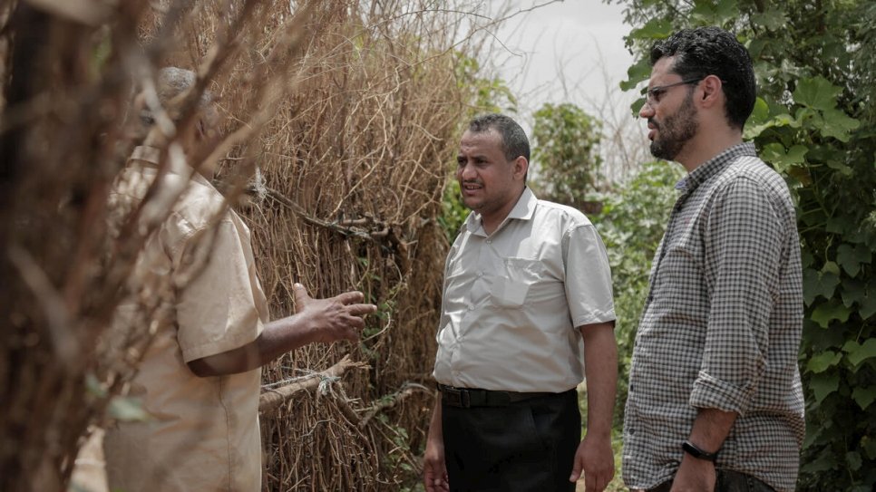 Ameen Jubran (centre), head and co-founder of Jeel Albena, talks to a displaced man at a camp near Hudaydah, Yemen. © UNHCR/Abdulhakeem Obadi