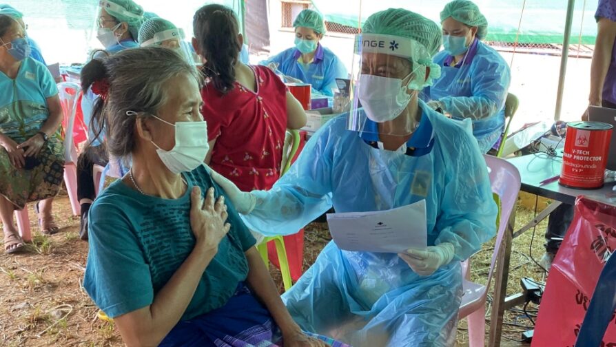 Lar Er discusses her fears relating to vaccines with Saya Piyapit, a nurse with IRC, during the vaccination drive at Tham Hin camp in November 2021. © UNHCR/Morgane Roussel-Hemery