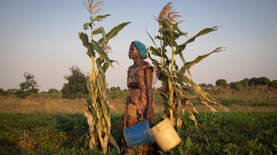 Dorotea gets ready to return home after watering her potato field. The money she makes from selling the potatoes is not enough to support her seven children. © UNHCR/Hélène Caux