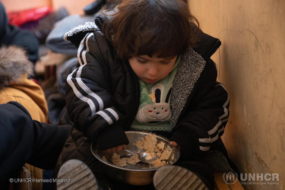 A young girl eats some bread at the school in Salahadin neighbourhood, which now hosts dozens of families from Aleppo displaced by the earthquakes. © UNHCR/Hameed Maarouf