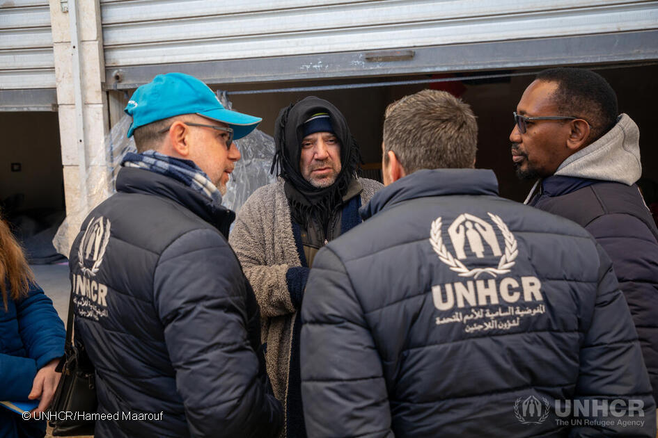 Mazen (centre), a father of four from Aleppo whose home was damaged by the earthquakes, meets UNHCR staff outside the retail unit in Al-Harir souq where his family are staying. © UNHCR/Hameed Maarouf