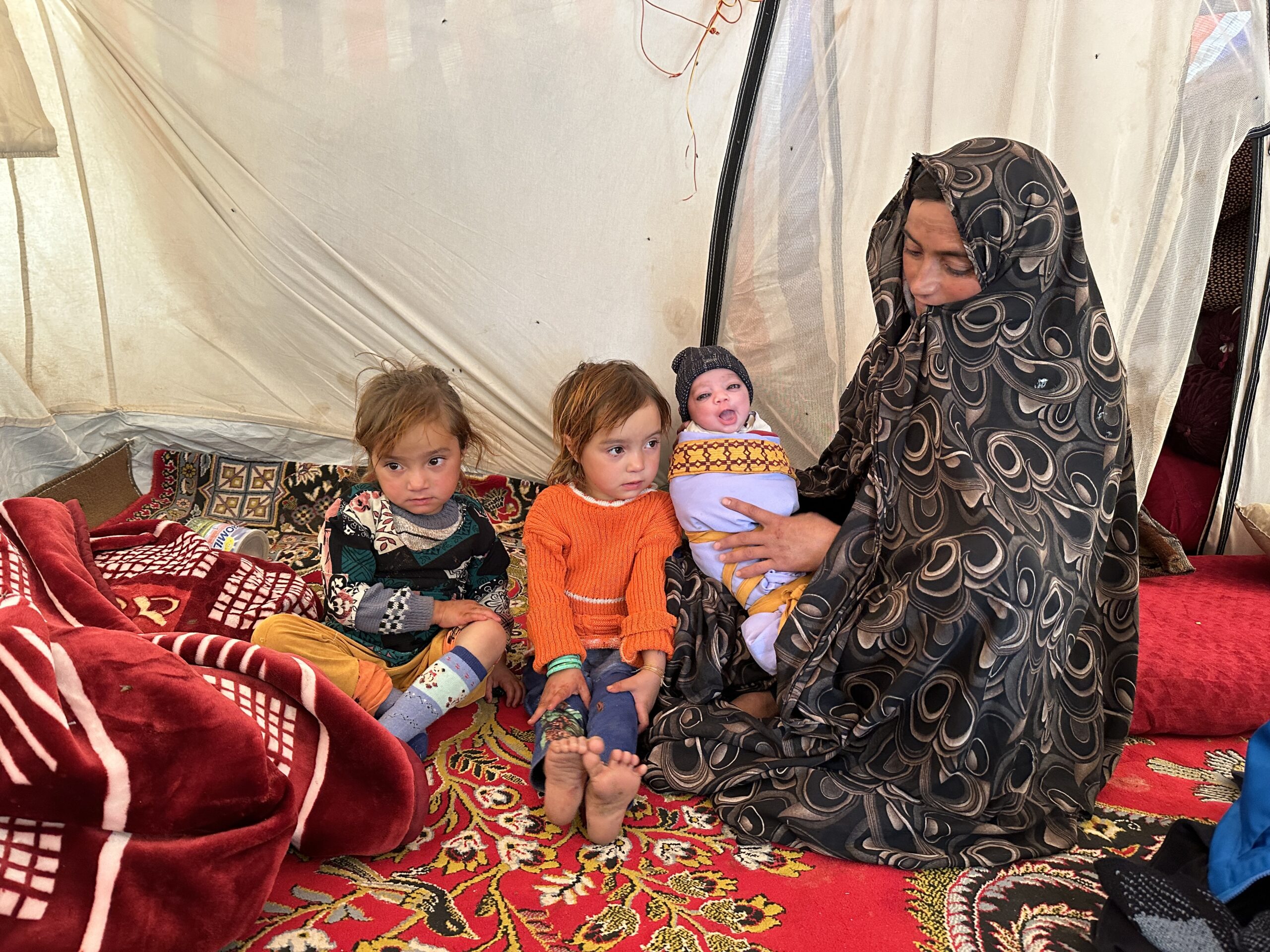 Sharifa with her baby daughter, Marzia, and 4-year-old twins Rokshana and Sabriya. Another daughter was killed when the family's home collapsed during the first earthquake.<br />
© UNHCR/Caroline Gluck