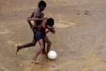 Children make up about 65 percent of the population at the Nayapara camp, but there is little for them to do. Here boys play football in the rain.