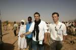 Un chargé de programmes de l'UNHCR explique à Julien Clerc comment les réfugiés soudanais du Darfour sont pris en charge à leur arrivée dans le camp provisoire de Mahamata, dans l'est du Tchad, mars 2004. 