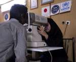 لاجئ أفغاني يخضع لفحص العين في مركز صحي في إيران.