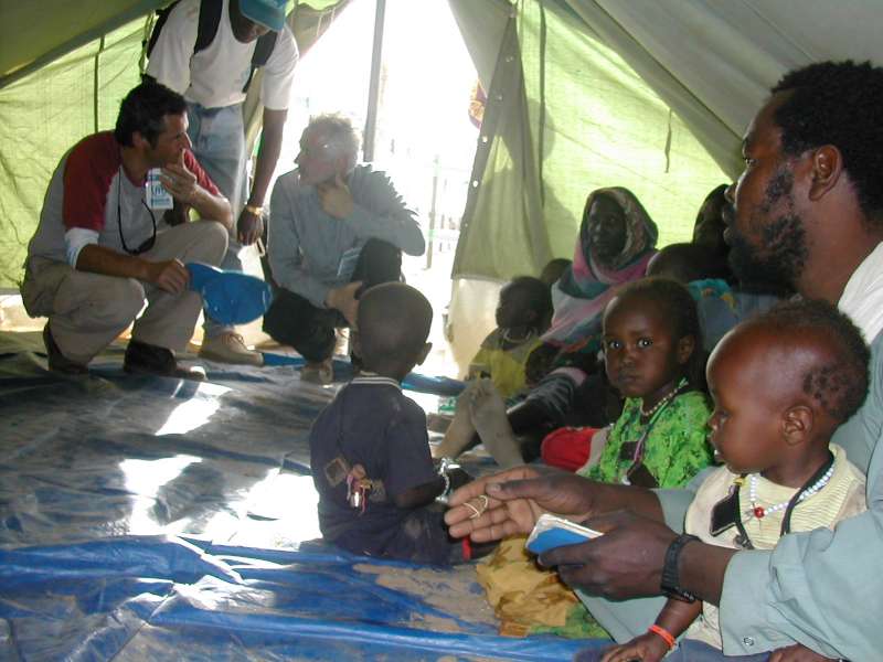 Un membre de l'équipe des secours d'urgence de l'UNHCR décrit les soins donnés aux réfugiés arrivant au camp de transit de Touloum, mars 2004. 