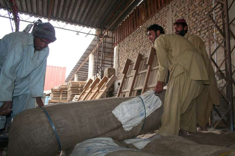 Dans l'entrepôt du HCR à Quetta, des tentes, des jerrycans, des seaux, des batteries de cuisine et des bâches en plastique sont chargés à bord de camions pour les distribuer aux survivants des inondations.  