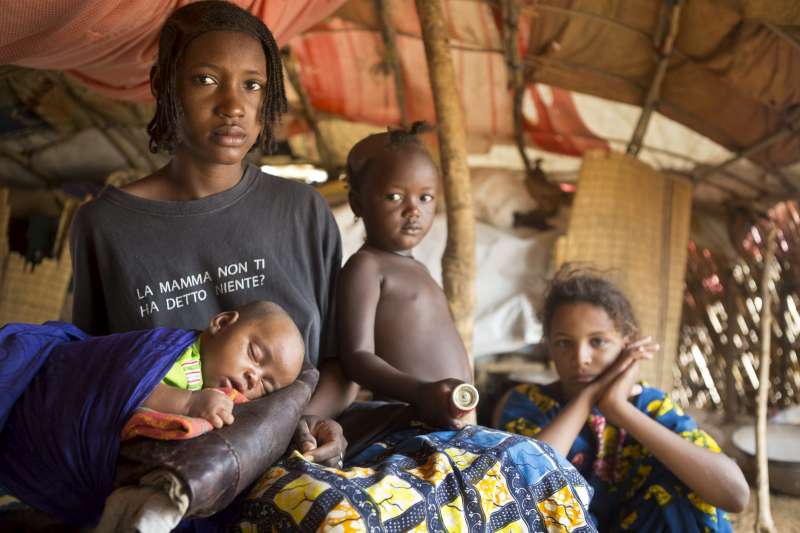 Fourteen-year-old Malian refugee Aminata takes care of her two-month old daughter Aichatou. She walked from northern Mali to Damba refugee camp in Burkina Faso with her daughter and mother. Aminata's husband is a migrant labourer in Côte d'Ivoire. 