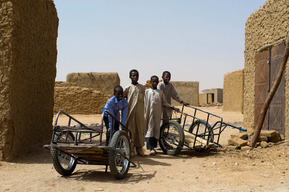 To earn money for food, refugee children in Iridimi camp often skip school on market days. Like these boys, they mainly carry goods on trolleys for local traders.