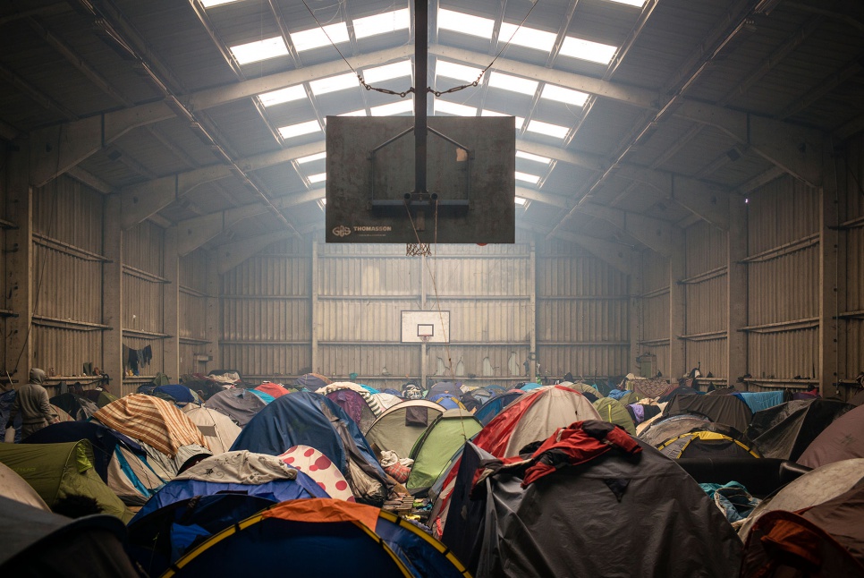 An old basketball court, once part of the Tioxide chemical plant, now provides shelter to hundreds of refugees and migrants in Calais, France.