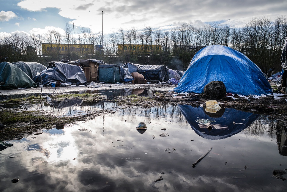 In an area known as the Jungle, refugees and migrants sleep in tents and makeshift shelters near a road that leads to the ferries they hope will take them to England.
