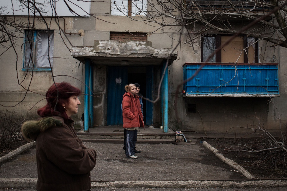 Oksana, 40, and her neighbours take in some fresh air after staying in the basement of their building in the Kievsky district of Donetsk, Ukraine.