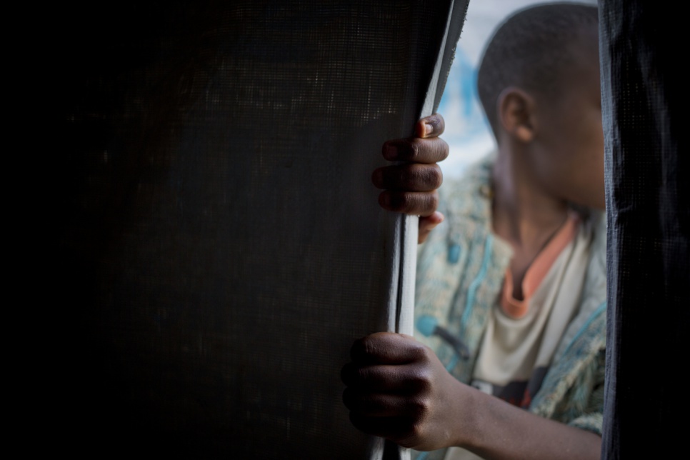 Jeanne's son Charles, 12, explores the tent where they are staying at Rwanda's Bugesera transit centre, after fleeing violence in Burundi.