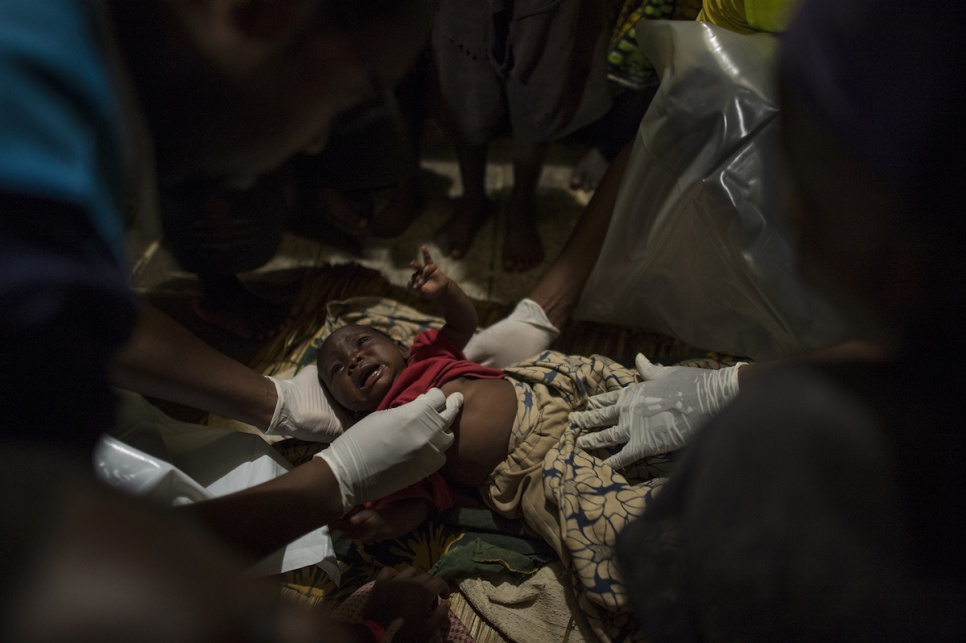 Sick with acute diarrhoea, a Burundian child receives care from health specialists working for UNHCR and its partners aboard the MV Liemba during the voyage from Kagunga to Kigoma.