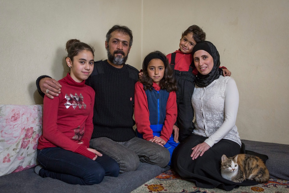 Hassan and Heba pose for a family portrait with their children -- Hevy, 14, Asmahan, 9, and Jaafar, 4 -- in their home in Lebanon's Bekaa Valley. They fled Syria in 2013.