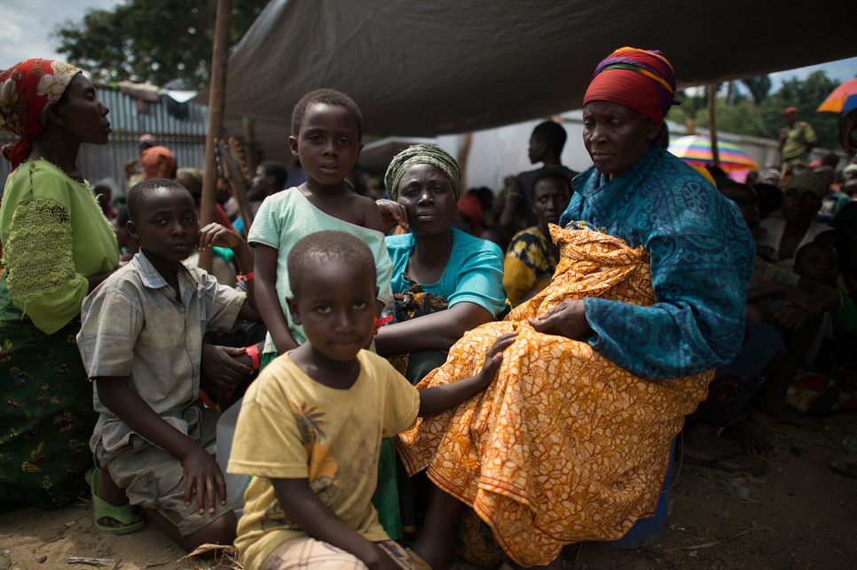 Foibe (centre) waits on the shores of Lake Tanganyika with her mother, nephew and two granddaughters. A ferry will take them from Kagunga to Kigoma in Tanzania.