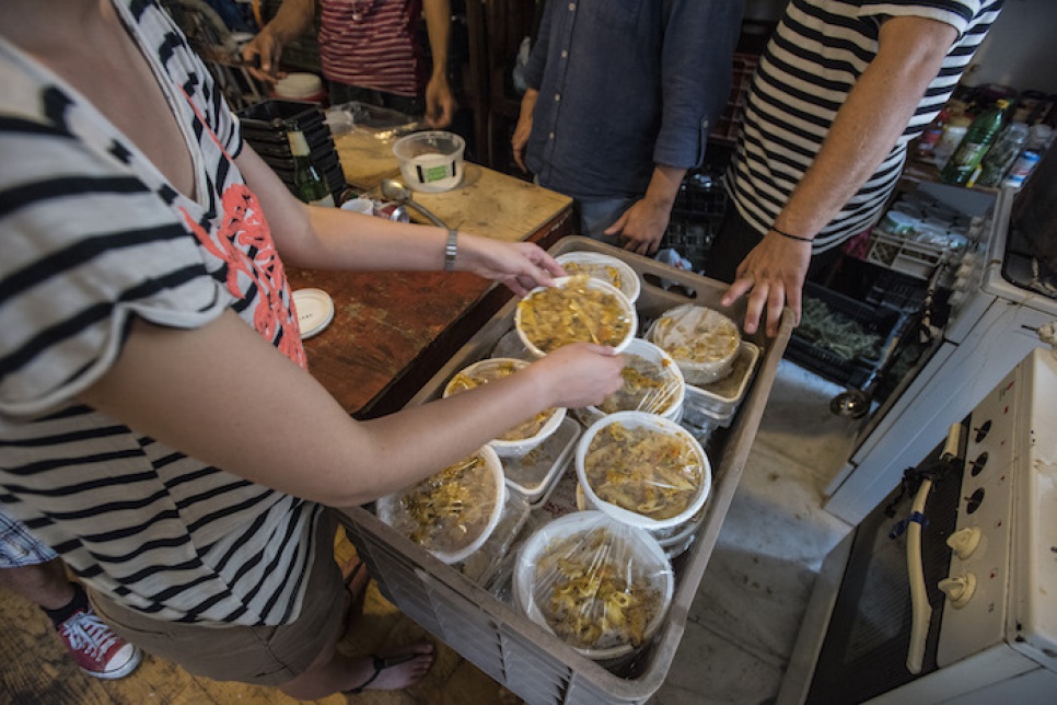 Volunteers prepare 100 vegetarian meals which will be distributed to refugees on the streets of Budapest.