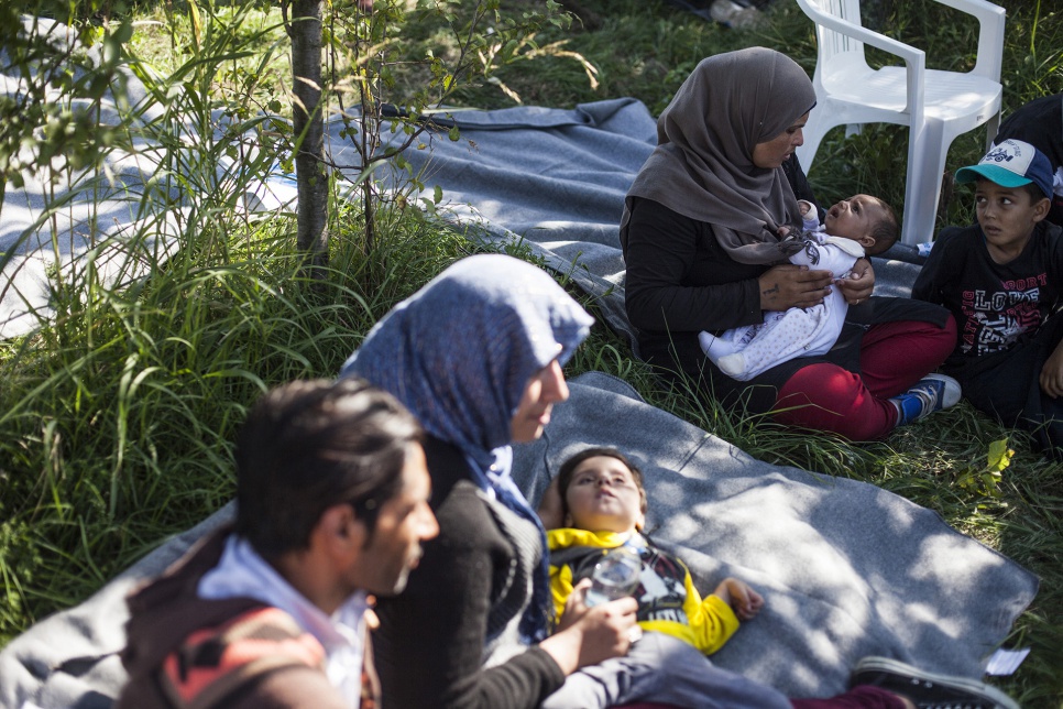 Two families with young children rest near the border crossing at Bapska, Croatia.