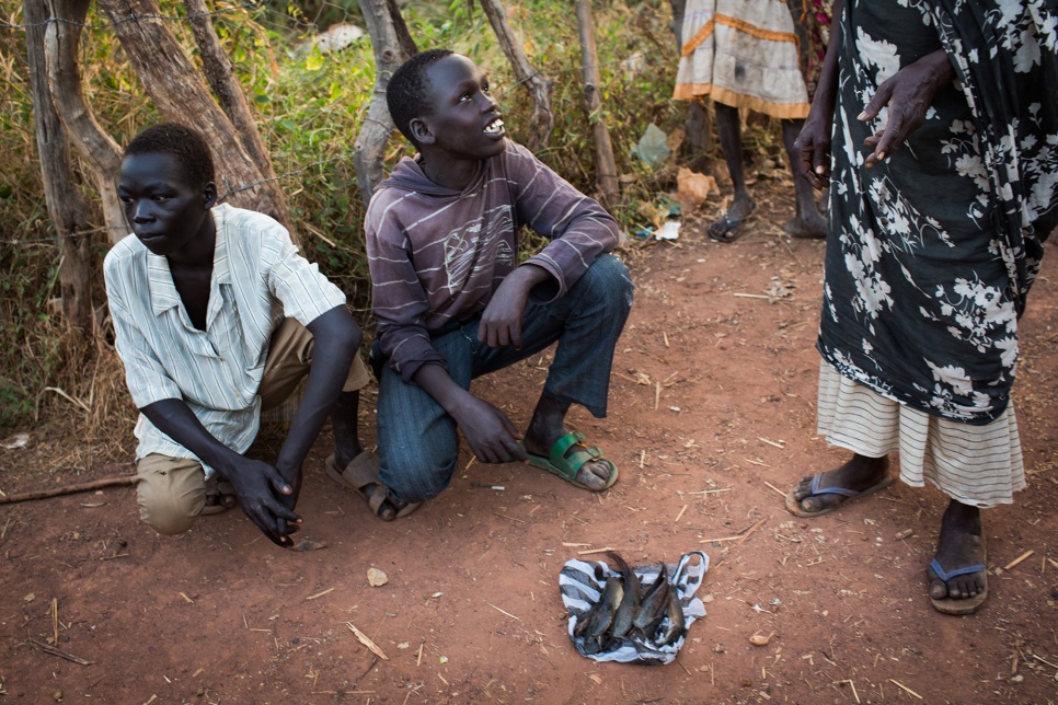 At the market in Yida, South Sudan, Kir Buth, 15, and Dictor Arak, 15, try to sell the mudfish they caught in a nearby swamp. Dictor was displaced from his home in Bentiu when fighting broke out between government and opposition troops in December 2013. He fled north to Yida with his family.<br><br>"I was living in Bentiu there and things were okay," Dictor says. "We were at school and my father was working and bringing us some money so that we could study. Then there was this war that started between the Dinkas and the Nuers. It is nothing to do with most of us, but it became very dangerous there. People were being killed everywhere. We had to run, without even carrying one piece of our property."