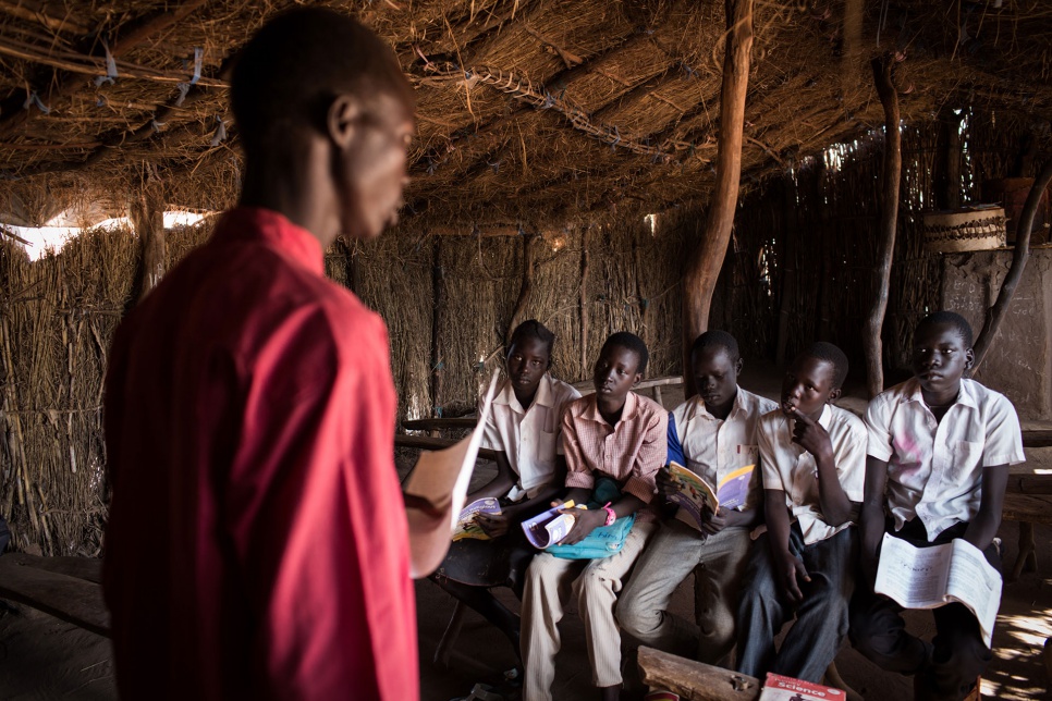 Second from right, Dictor Arak, 15, joins other students in a class at Yida Refugee Primary School in Yida, South Sudan. Dictor, who dreams of becoming a doctor, pays for his schoolbooks with the money he earns from catching and selling mudfish.