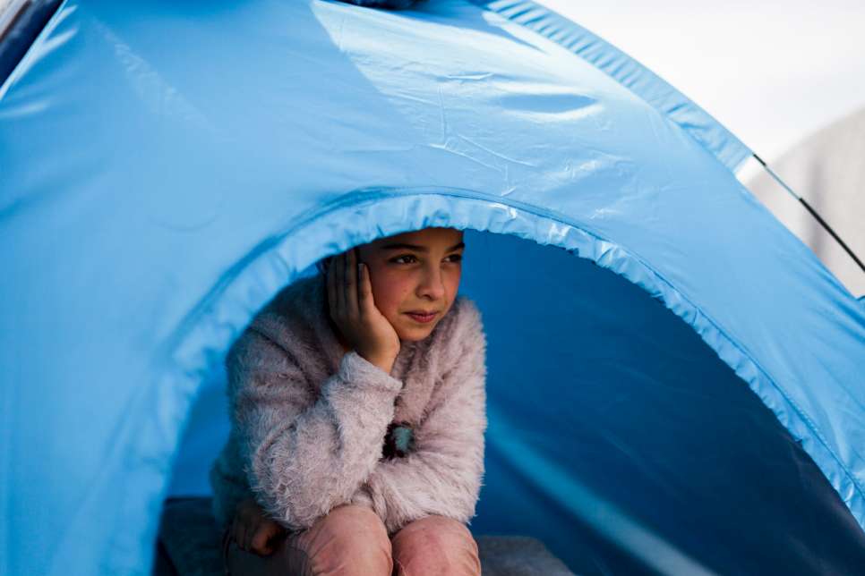 Adiba, 11, sits inside the small camping tent she shares with her mother and her four siblings.
