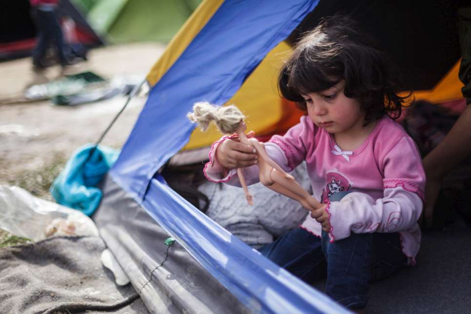 Sedra, 4, plays with a Barbie doll inside the small camping tent she shares with her mother and her four siblings.
