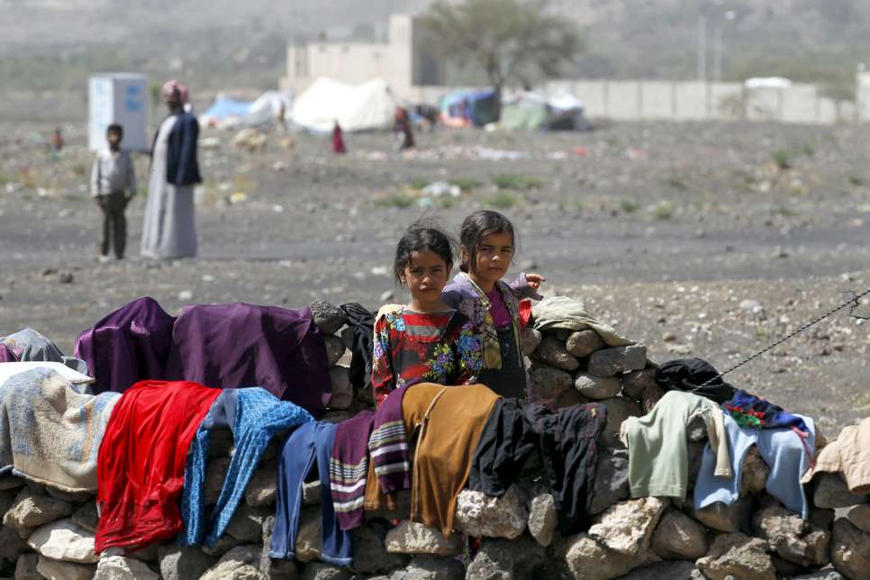 Deux enfants yéménites déplacés - Mouna, 9 ans, et Swkina, 8 ans - se tiennent hors de la tente de leur famille au camp de Darwin, dans la province d'Amran, au nord du Yémen.