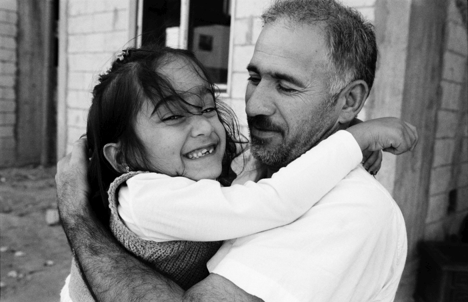 Aya dans les bras de son père, alors qu'ils se préparent à quitter le Liban pour se réinstaller en France.