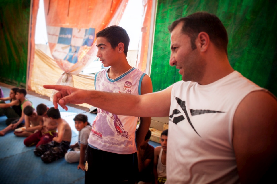Mohammed Lakash écoute son coach de lutte, Mohammed Al Akrad, au centre de remise en forme du camp de réfugiés de Zaatari en Jordanie. 