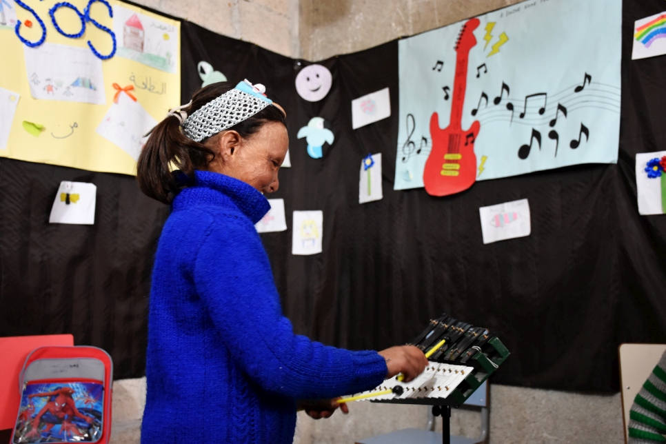 Wafaa joue de la musique dans une salle de classe à l'abri temporaire, où elle a enfin pu commencer son éducation et aller à l'école pour la première fois.