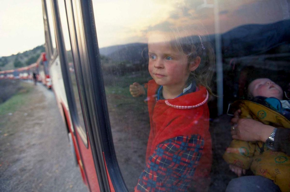 طفلة لاجئة من كوسوفو* تنظر من نافذة قطار متّجه إلى مطار سكوبيه. نُقلت عائلتها إلى ألمانيا في يونيو 1999 في إطار برنامج إجلاء إنساني.