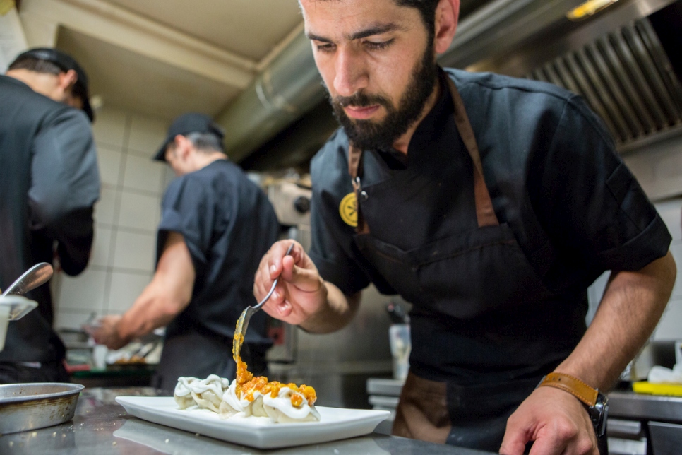 الطاهي الأفغاني رضا غلامي يطهو في مطبخ مطعم "إيت" في باري، إيطاليا.