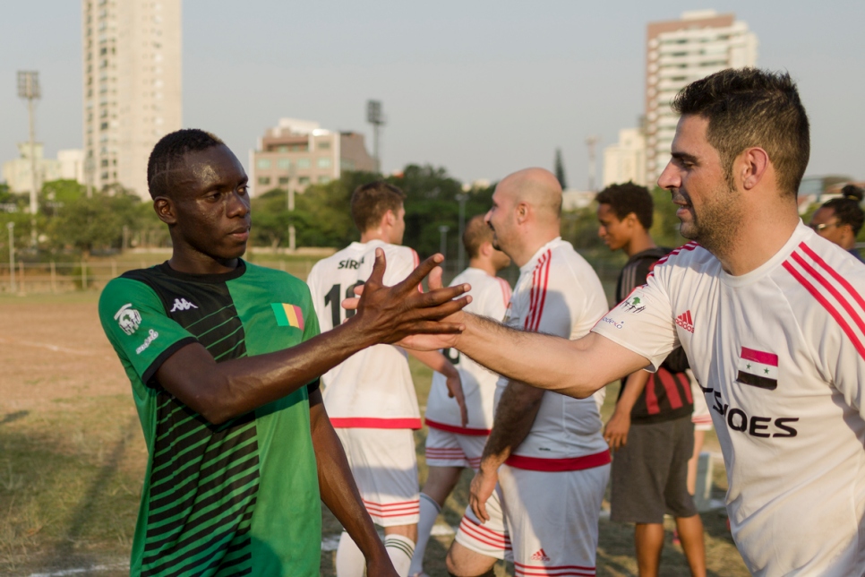اللاعبون السوريون والماليون يتصافحون بعد مباراتهم في بطولة كأس العالم للاجئين في ساو باول، البرازيل.