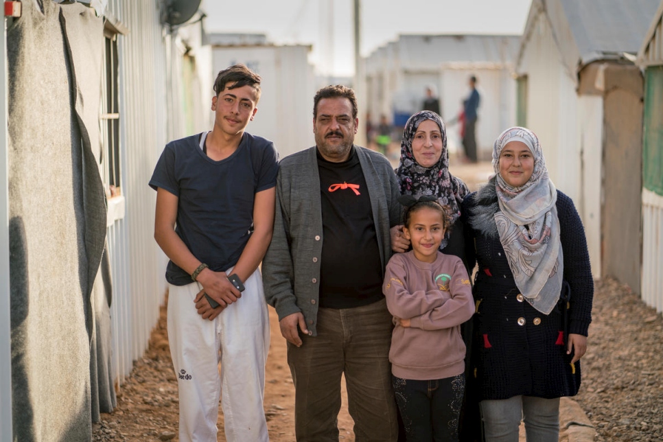 اللاجئ السوري إحسان الخليل وزوجته رباب وثلاثة من أولاده يقفون خارج مسكنهم في مخيم الأزرق للاجئين في الأردن.